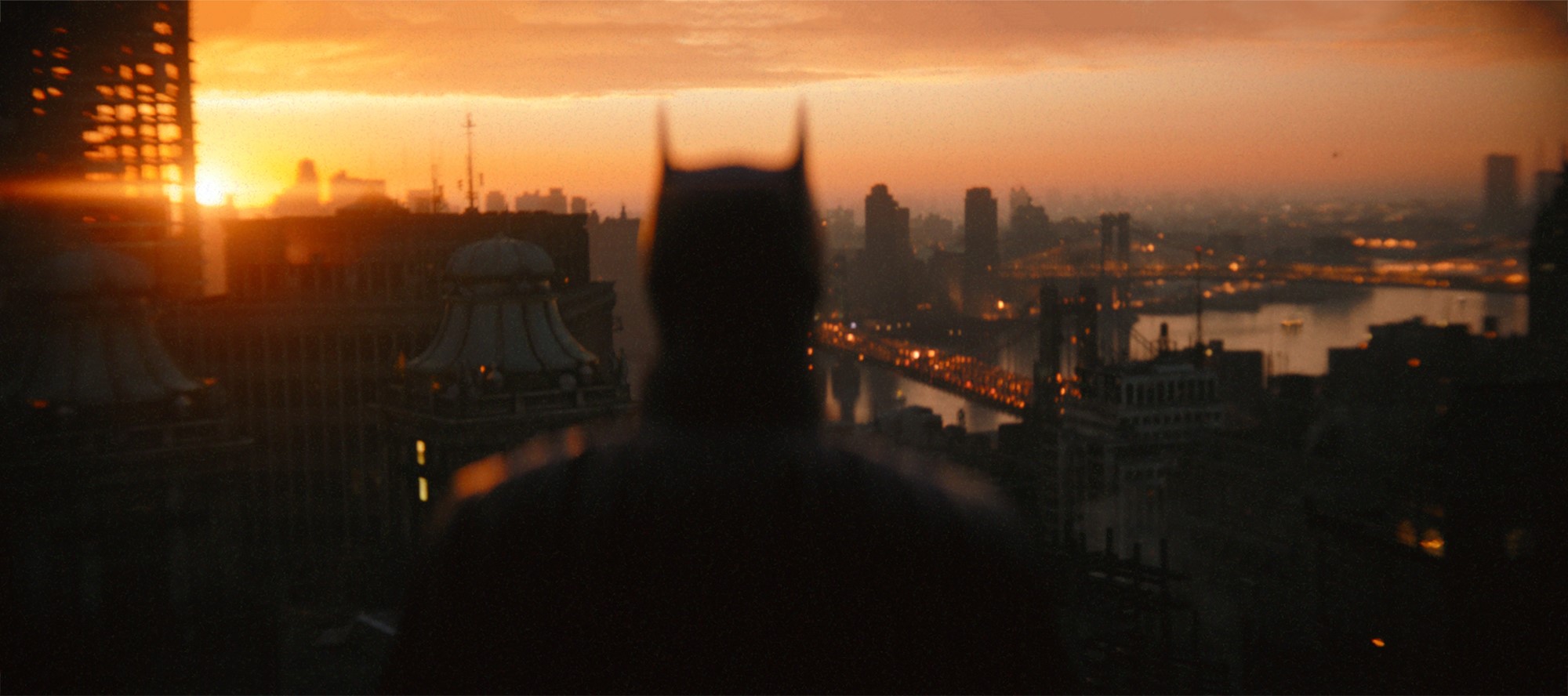 The Batman (2022) review. Batman looks at the sunset in Gotham City.